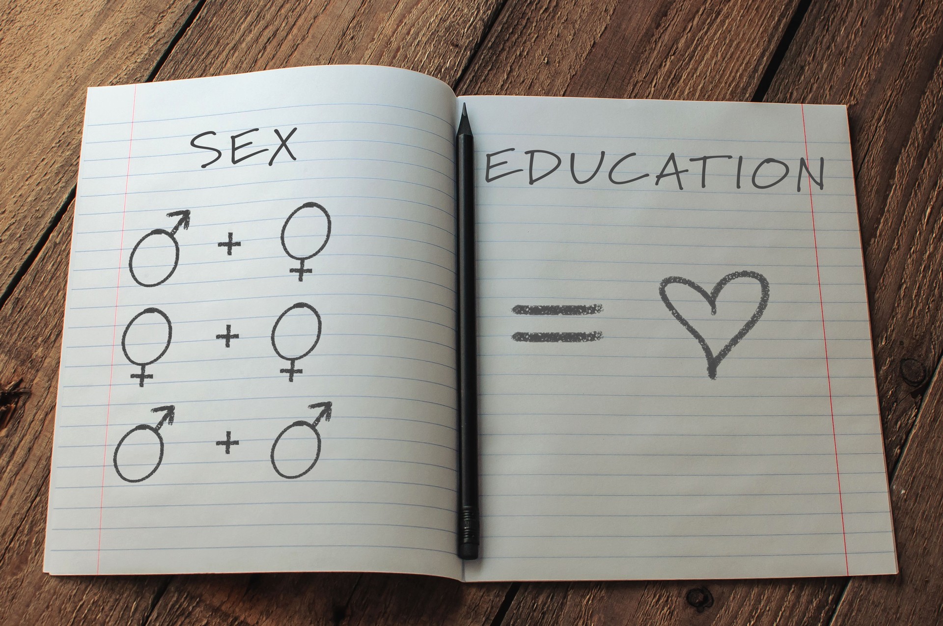 Notebook with a pencil and a heart drawn on it